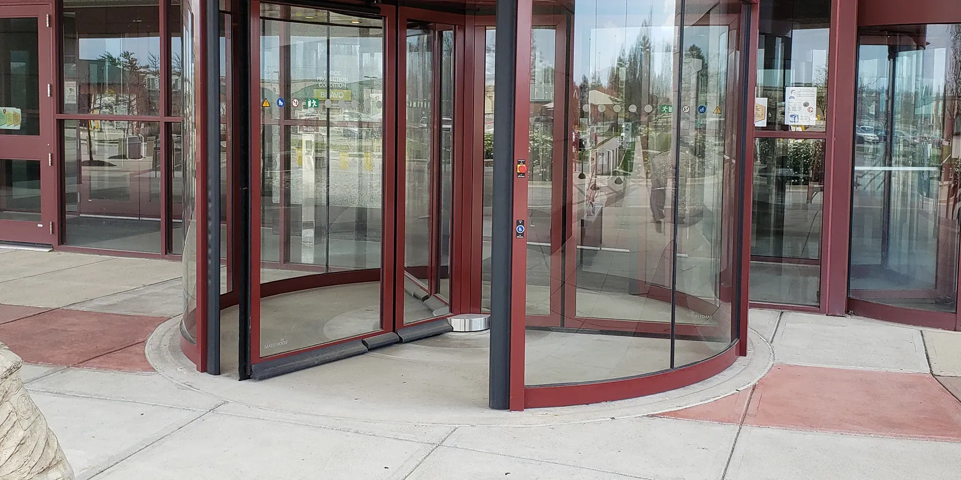 Comparison of revolving door and sliding door in a commercial setting, emphasizing energy efficiency and maintenance